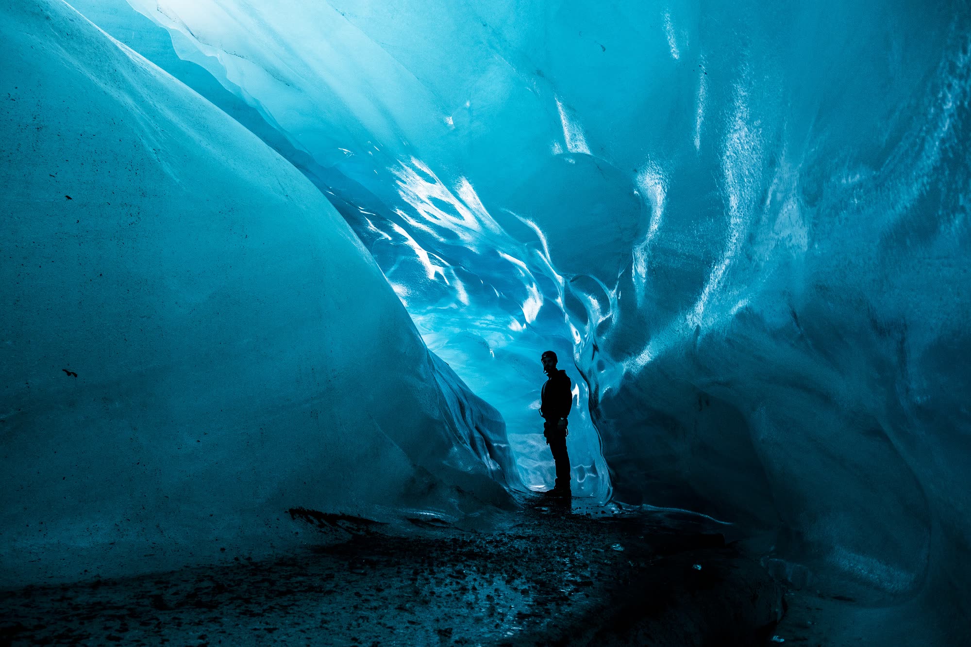 Người đứng trong hang băng xanh dưới sông băng, Iceland